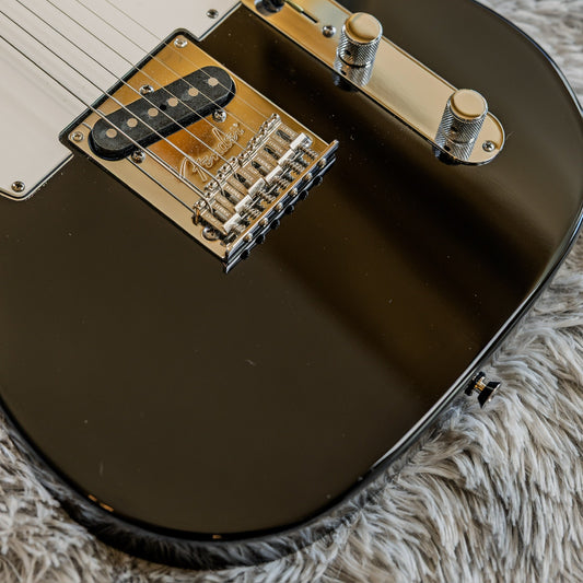 Close-up of the six-saddle bridge on a black Fender American Standard Telecaster where the string break angle over the saddles is set.