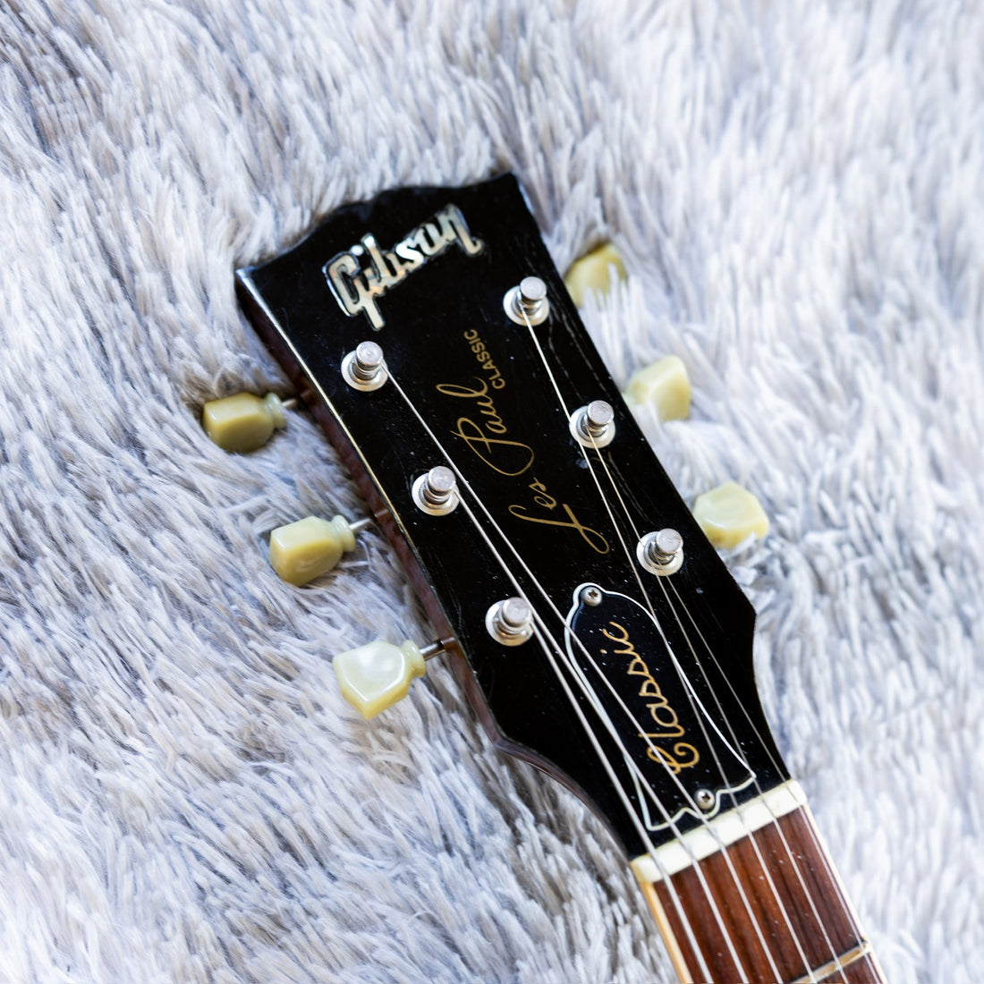 Gibson Les Paul headstock with the bell-shaped truss rod cover between the tuners