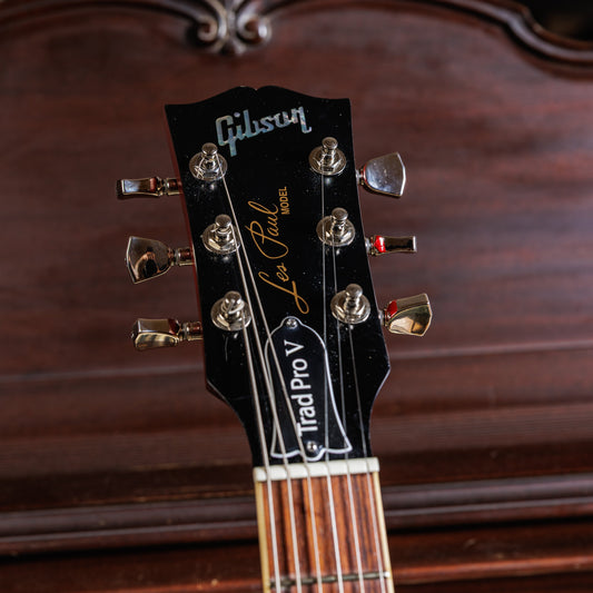 Front of a Gibson Les Paul headstock showing strings wound around the tuner posts, where most new-string slack hides.