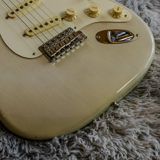 Vintage six-screw synchronized tremolo bridge on a white Fender Stratocaster, illustrating a floating bridge that pivots