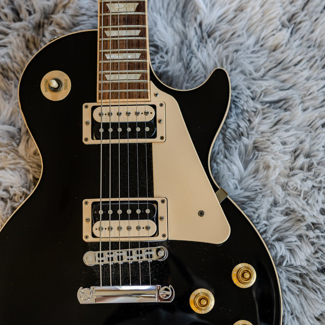 Close-up of two uncovered humbucker pickups on a black Gibson Les Paul