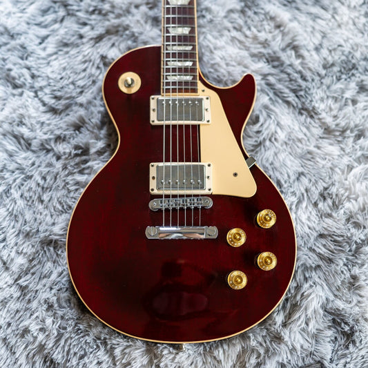 A pair of covered humbuckers on a wine-red Gibson Les Paul Standard, the pickups whose Alnico magnets this article compares