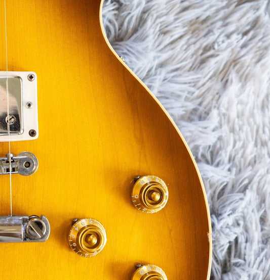 Gold speed knobs on a honey-burst Gibson Les Paul, the two lower knobs being the tone controls wired to tone capacitors