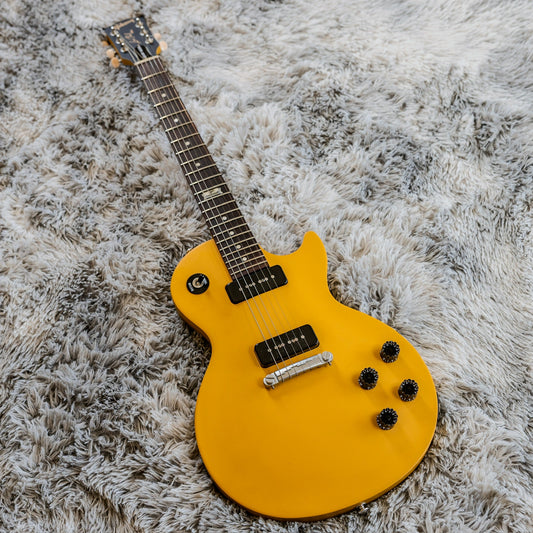 TV Yellow Gibson in the Les Paul Junior lineage with soapbar P-90 pickups and a wraparound bridge on a grey rug.