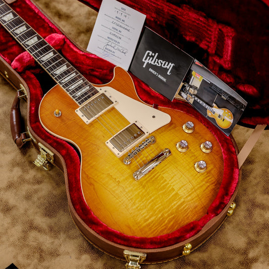 Gibson Les Paul Standard '60s in Unburst with a figured maple top and trapezoid inlays, shown in its case with Gibson paperwork.