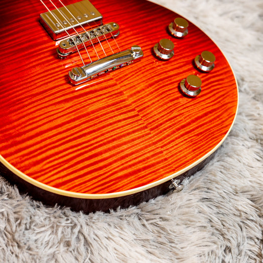 Close-up of the four control knobs on a flame-top Gibson Les Paul, the two lower knobs being the tone controls