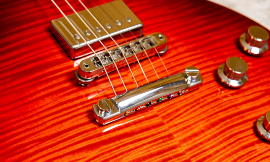 Close-up of a Tune-o-matic bridge and stopbar tailpiece on a Gibson Les Paul Standard HP in Heritage Cherry Fade