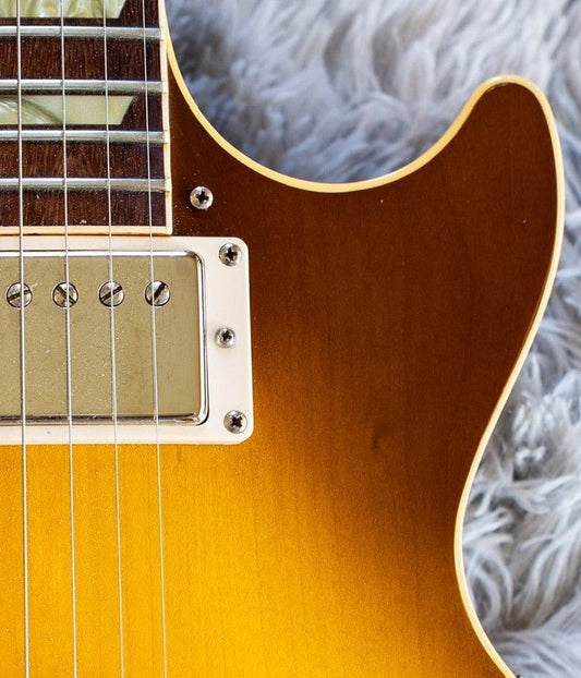 Close-up of a Gibson Les Paul humbucker in its mounting ring, showing the two height-adjustment screws that flank the pickup bezel