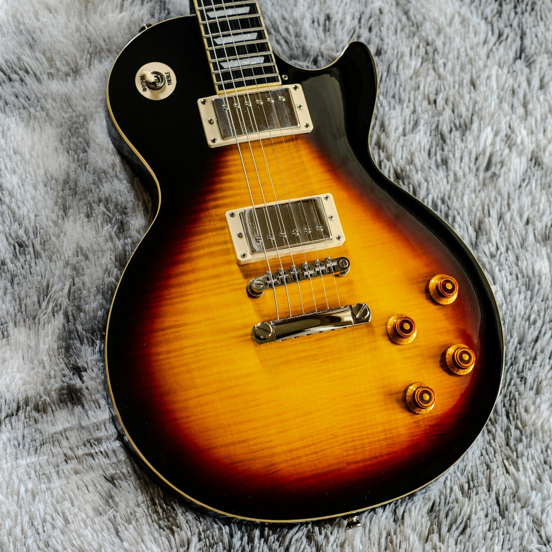 Epiphone Les Paul Standard Plus Top PRO in Bourbon Burst laid on a soft grey blanket