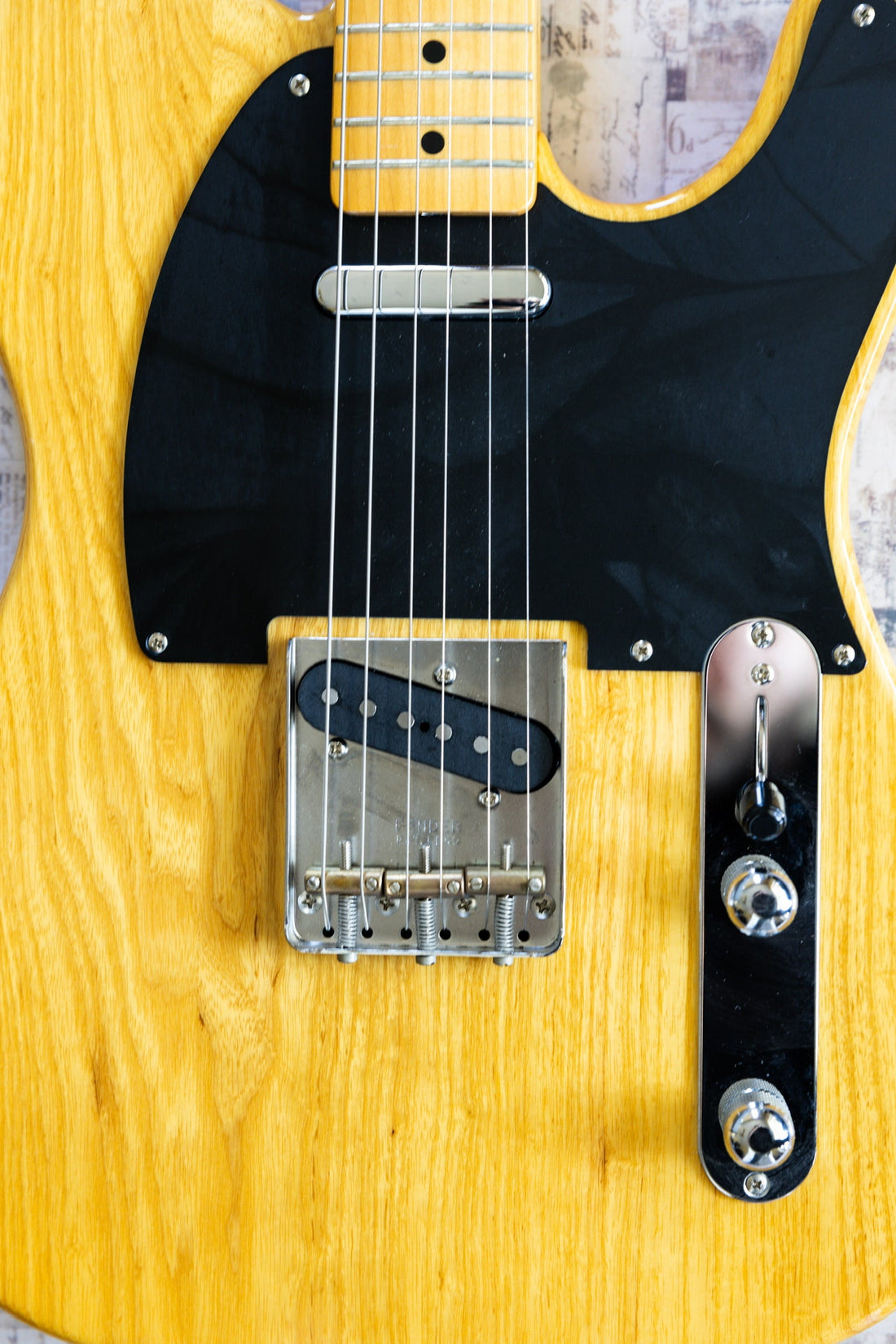 Close-up of a Fender Telecaster showing the chrome-covered neck pickup and the bare bridge pickup in a steel bridge plate