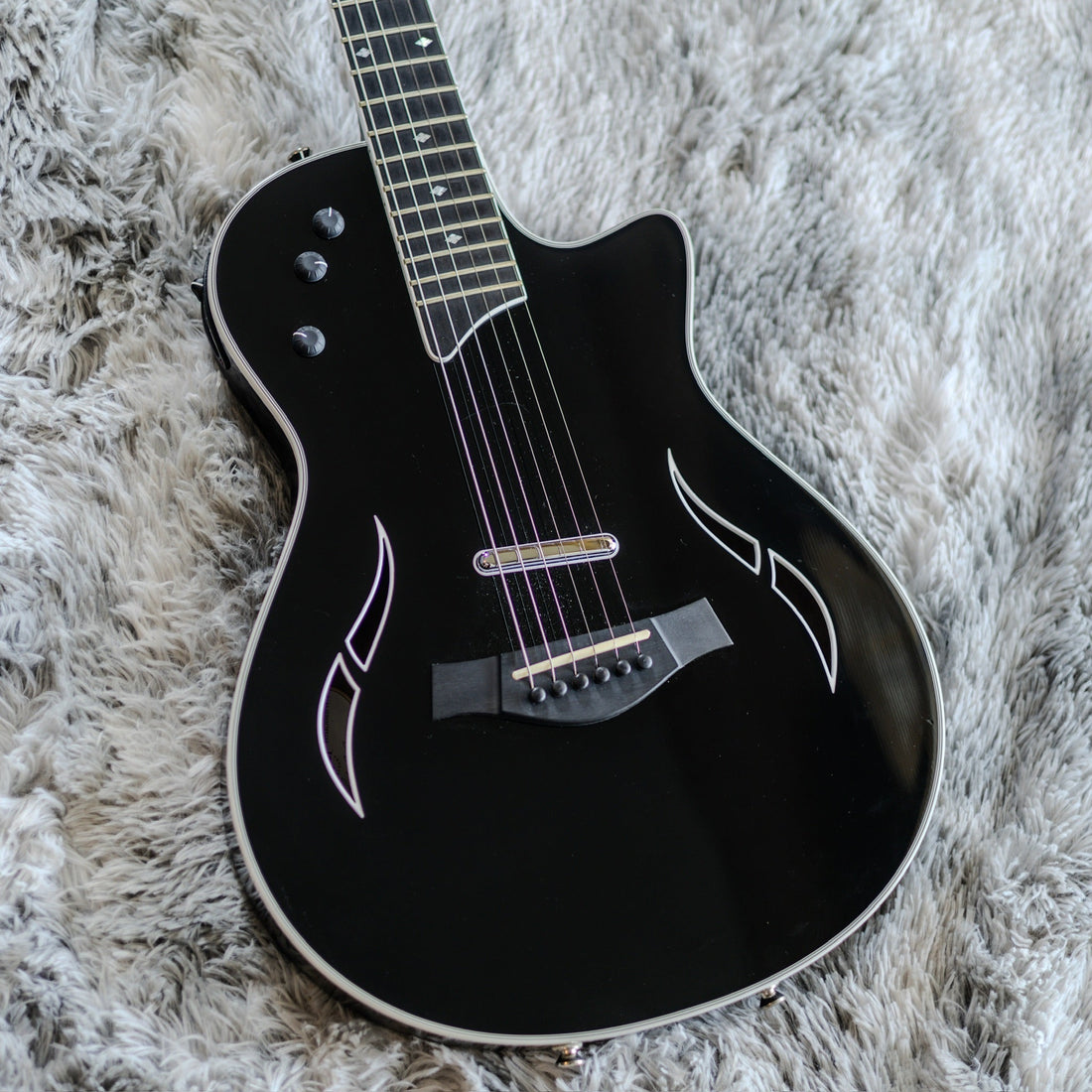 Black Taylor T5z Standard hollowbody hybrid guitar showing the visible bridge humbucker, f-hole, and acoustic-style pin bridge.